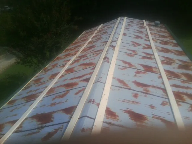 Rusted metal roof panels with new wood purlins before replacement — Storm Damage Roof Repair in Clarkston by Roofing Brothers